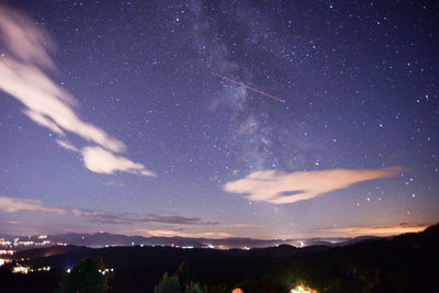 Silhouette landscape against sky at night