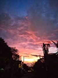 Silhouette of trees against cloudy sky