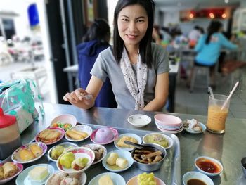 Young woman having food on table