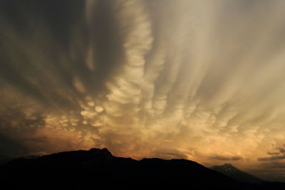 Low angle view of silhouette mountain against dramatic sky