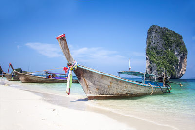 Boat moored on beach against sky