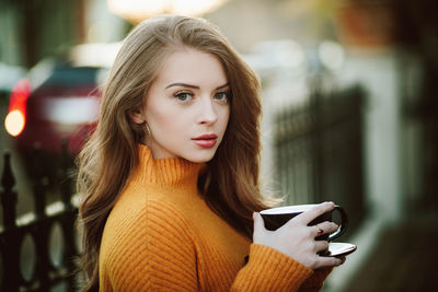 Portrait of young woman drinking coffee