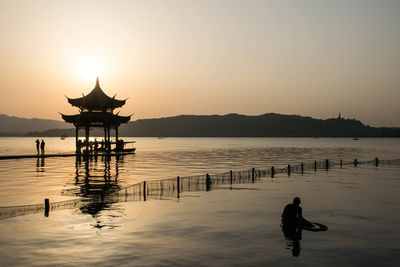 Silhouette of lake against clear sky