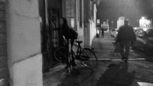 Rear view of people riding bicycle on street