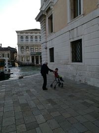 People on street amidst buildings in city