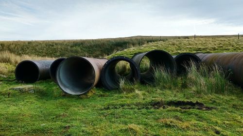 Pipes on field against sky