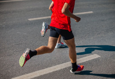 Low section of man skateboarding on road