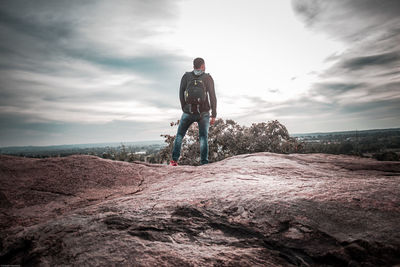 Man riding bicycle on mountain against sky
