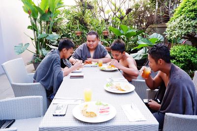 High angle view of family eating food and drink in yard