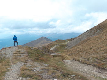 Man walking on mountain against sky