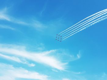 Low angle view of airplane flying against blue sky