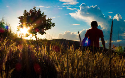 Rear view of silhouette man standing on field against sky