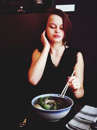 Portrait of young woman sitting at table