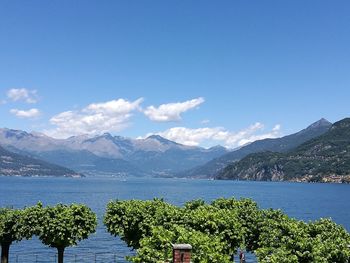 Scenic view of lake and mountains against blue sky