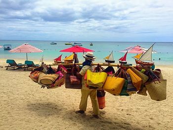 Lounge chairs on beach against sky