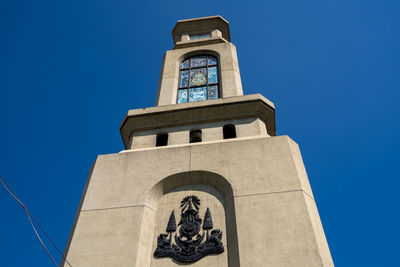 Low angle view of clock tower against clear blue sky