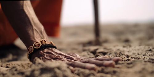 Low section of man standing on sand at beach