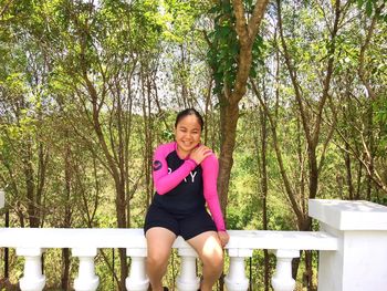 Portrait of smiling young woman standing in park