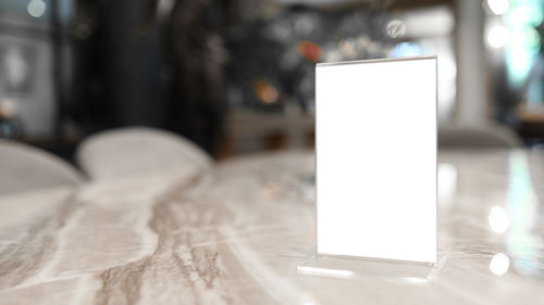 Close-up of illuminated light bulb on table at home