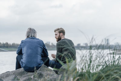 Father and son meeting at rhine river in autmn, talking together