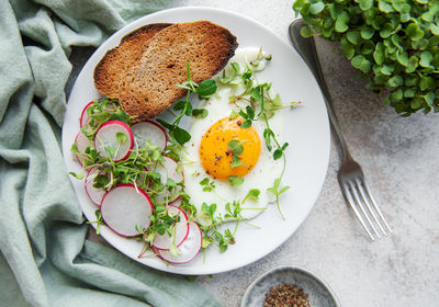 Delicious gourmet breakfast. rye bread with fried egg, freshly ground pepper and salad 