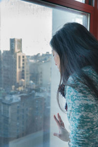 Woman looking through window