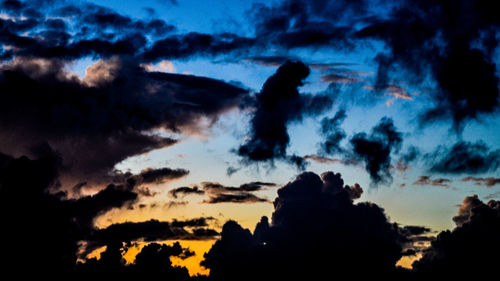 Silhouette of trees against cloudy sky