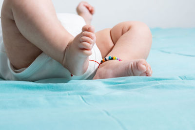 Beautiful and tender feet of a two months old baby, lying on a bed with blue sheets