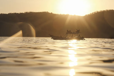 Group of people on the boat at sunset time