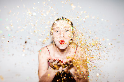 Young woman celebrating her 21st birthday illuminated with hard flash light.