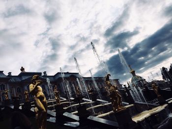 Low angle view of statue against sky and buildings