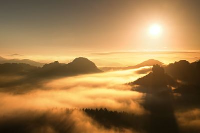 Sunrise in a beautiful mountain of czech-saxony switzerland. sandstone peaks against orange sun rays