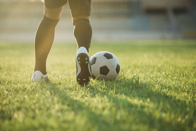 Low section of man playing soccer on field