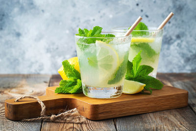 Two glass with lemonade or mojito cocktail with lemon and mint, cold refreshing drink.