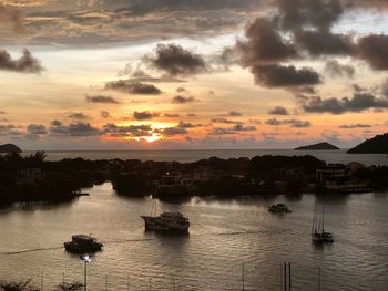 Sailboats in sea at sunset