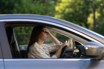 Side view of woman sitting in car