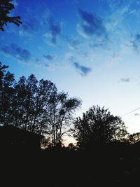 Low angle view of silhouette trees against sky