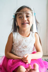 A toddler girl wearing the face protection shield. a safety corona mask during covid-19 pandemic.