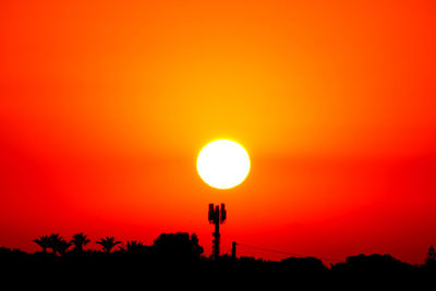 Silhouette trees against orange sky during sunset