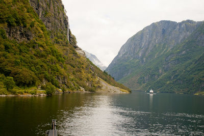 Scenic view of lake by mountains against sky