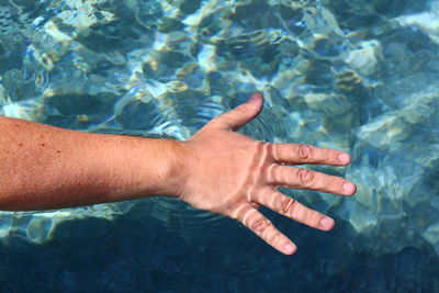 Hand of man touching water