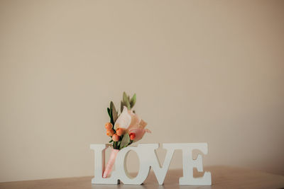 Red flower on table against wall