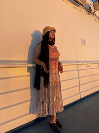 Woman looking at camera while standing against railing