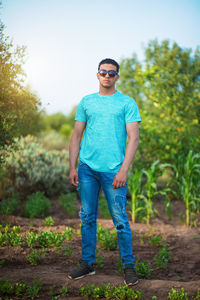 Portrait of young man standing against plants