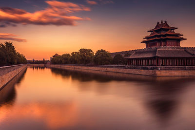 Reflection of building in lake during sunset