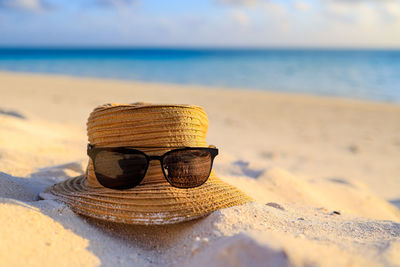 A hat and sunglasses at the beach