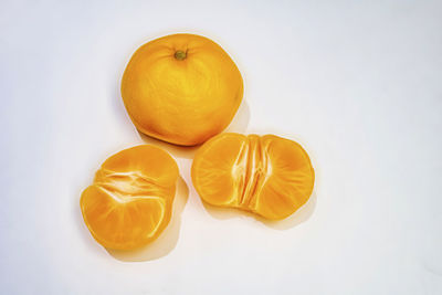 High angle view of orange fruit against white background