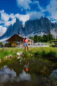 Reflection of man in lake against mountains