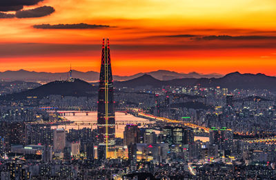 Illuminated cityscape against sky during sunset