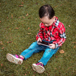 High angle view of girl sitting on grass